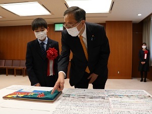 写真：斉藤国土交通大臣に作品の説明をする前野さん