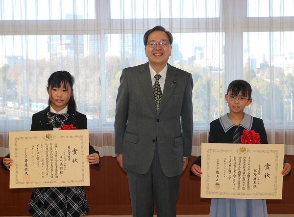 大臣を真ん中に両受賞者の写真